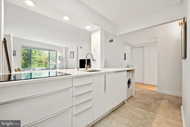 a view of kitchen with stainless steel appliances cabinets and refrigerator