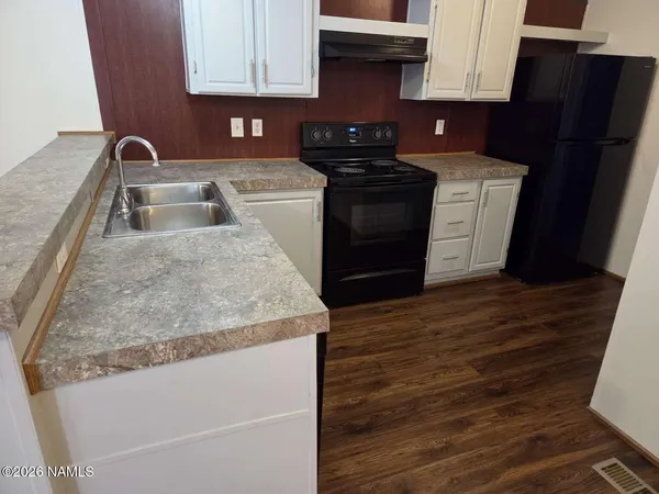 a kitchen with granite countertop a sink stove and refrigerator