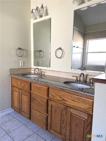 a bathroom with a granite countertop sink a large mirror and vanity