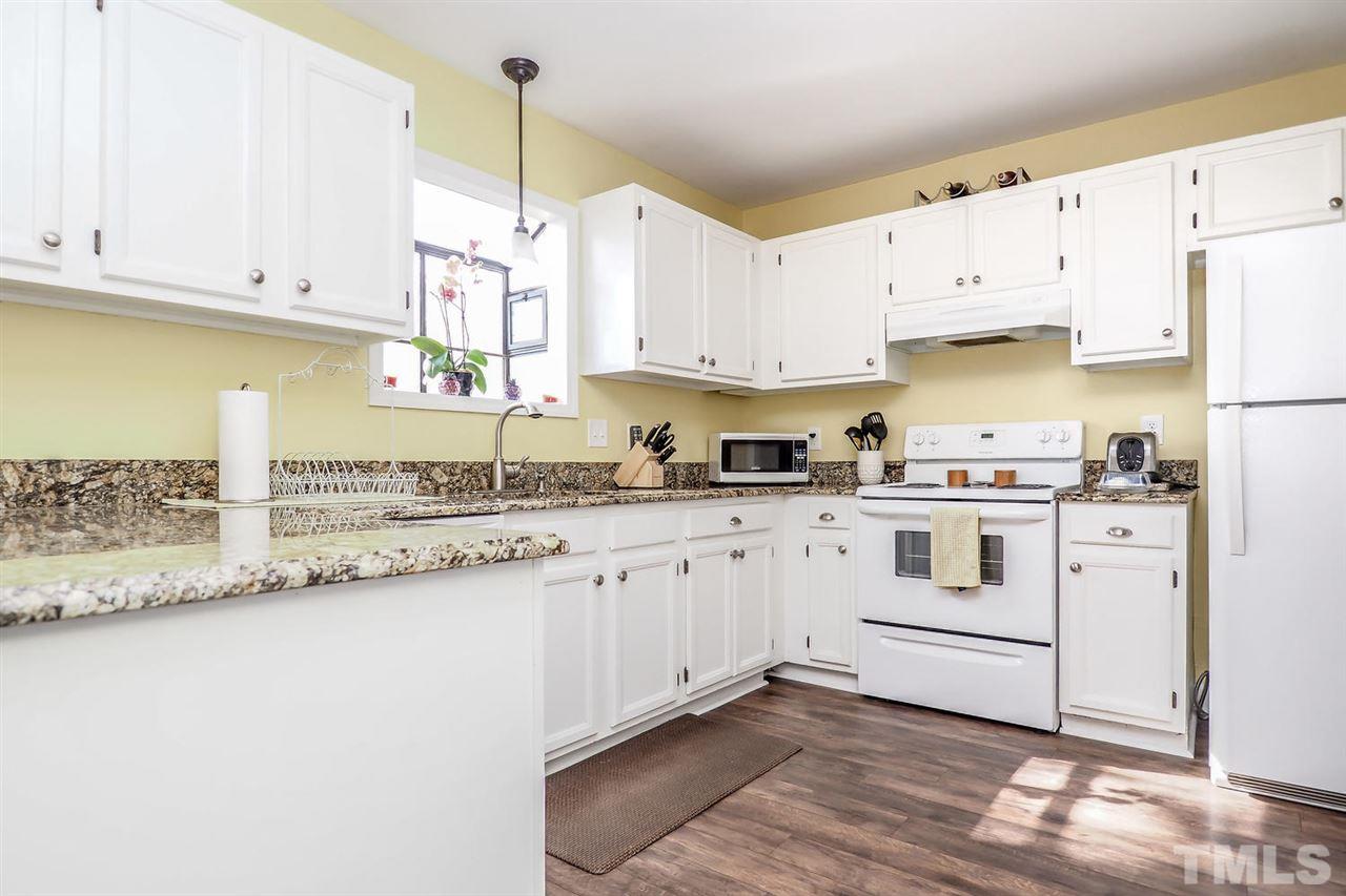 1713 Vintage Road Raleigh, NC 27610 - Photo 10 of 23 a kitchen with granite countertop white cabinets and white appliances