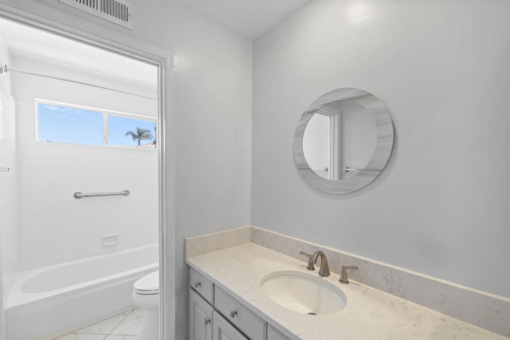 3355 Genoa Way, Unit 134 Oceanside, CA 92056 - Photo 30 of 45 a bathroom with a granite countertop sink mirror toilet and bathtub