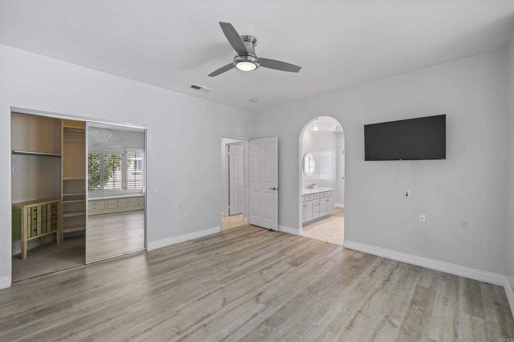 3355 Genoa Way, Unit 134 Oceanside, CA 92056 - Photo 35 of 45 an empty room with wooden floor a ceiling fan and windows