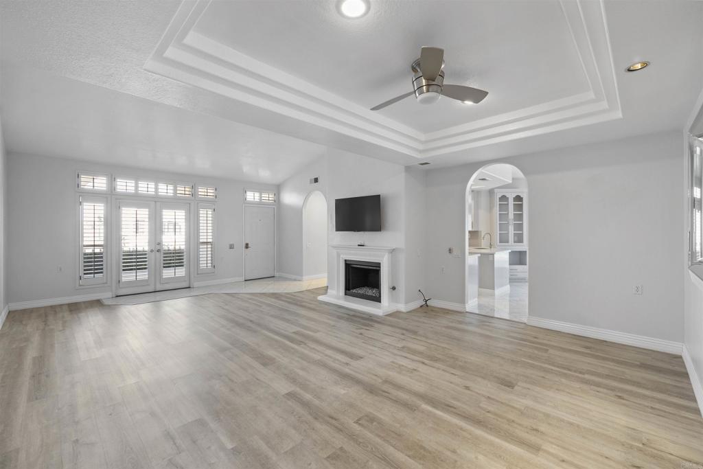 3355 Genoa Way, Unit 134 Oceanside, CA 92056 - Photo 4 of 45 a view of a livingroom with wooden floor a fireplace a ceiling fan and window