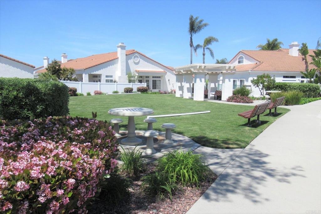 3355 Genoa Way, Unit 134 Oceanside, CA 92056 - Photo 42 of 45 a view of a white house next to a yard with big trees