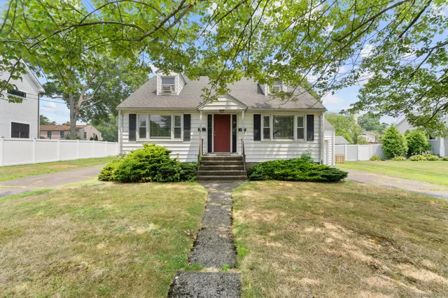 a front view of a house with a yard and potted plants