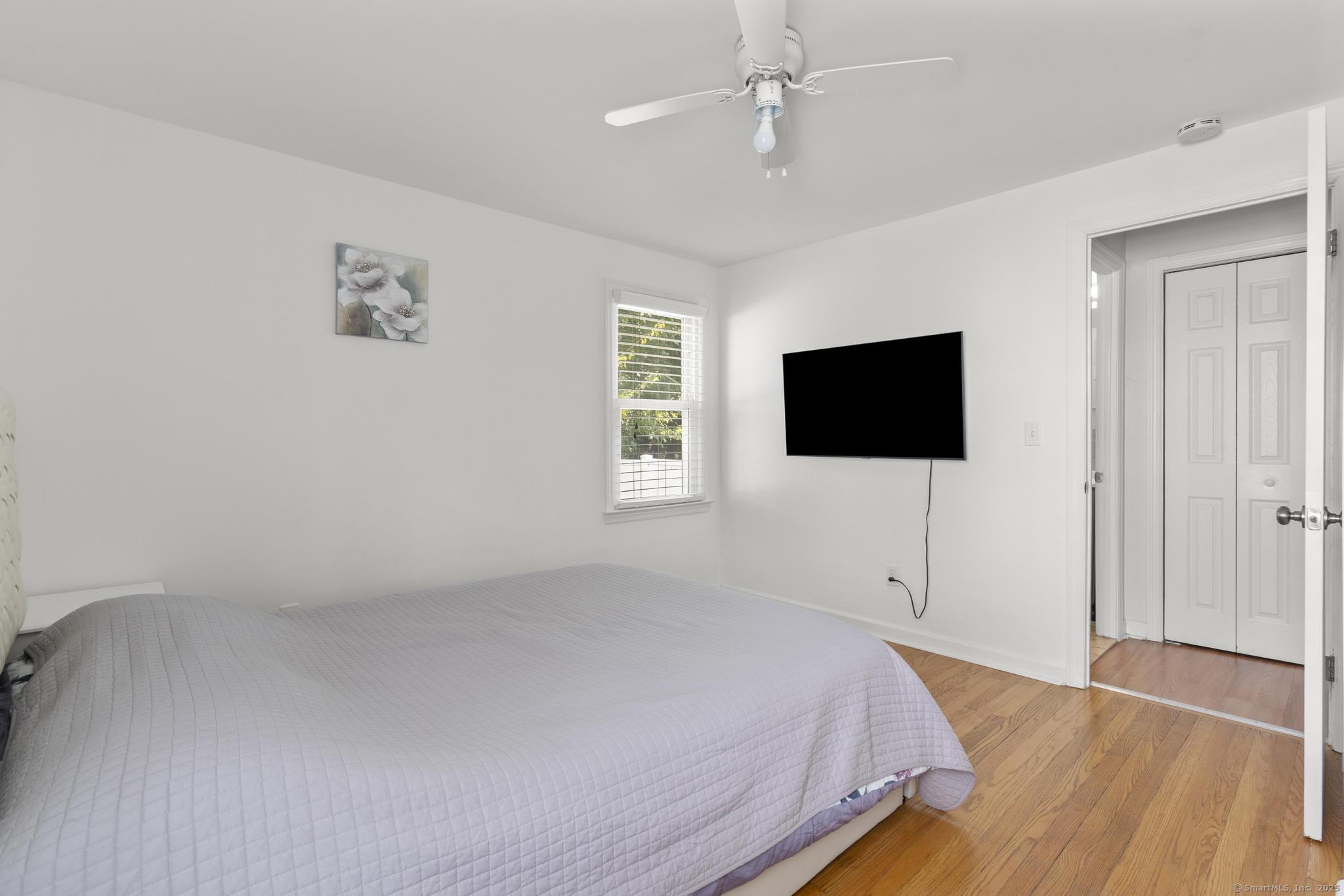 214 Country Road Fairfield, CT 06824 - Photo 11 of 20 a bedroom with a bed and a flat screen tv