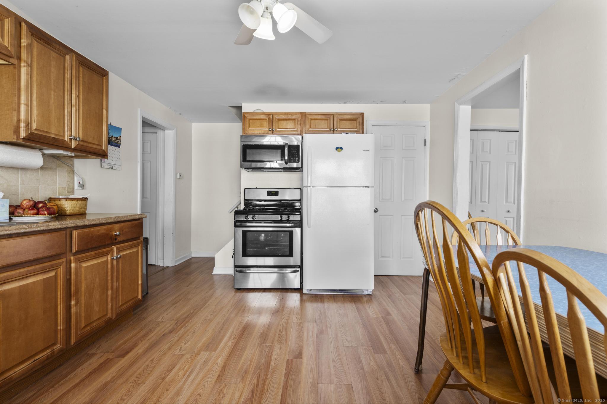 214 Country Road Fairfield, CT 06824 - Photo 9 of 20 a kitchen with stainless steel appliances granite countertop a refrigerator a stove a sink dishwasher and wooden floor