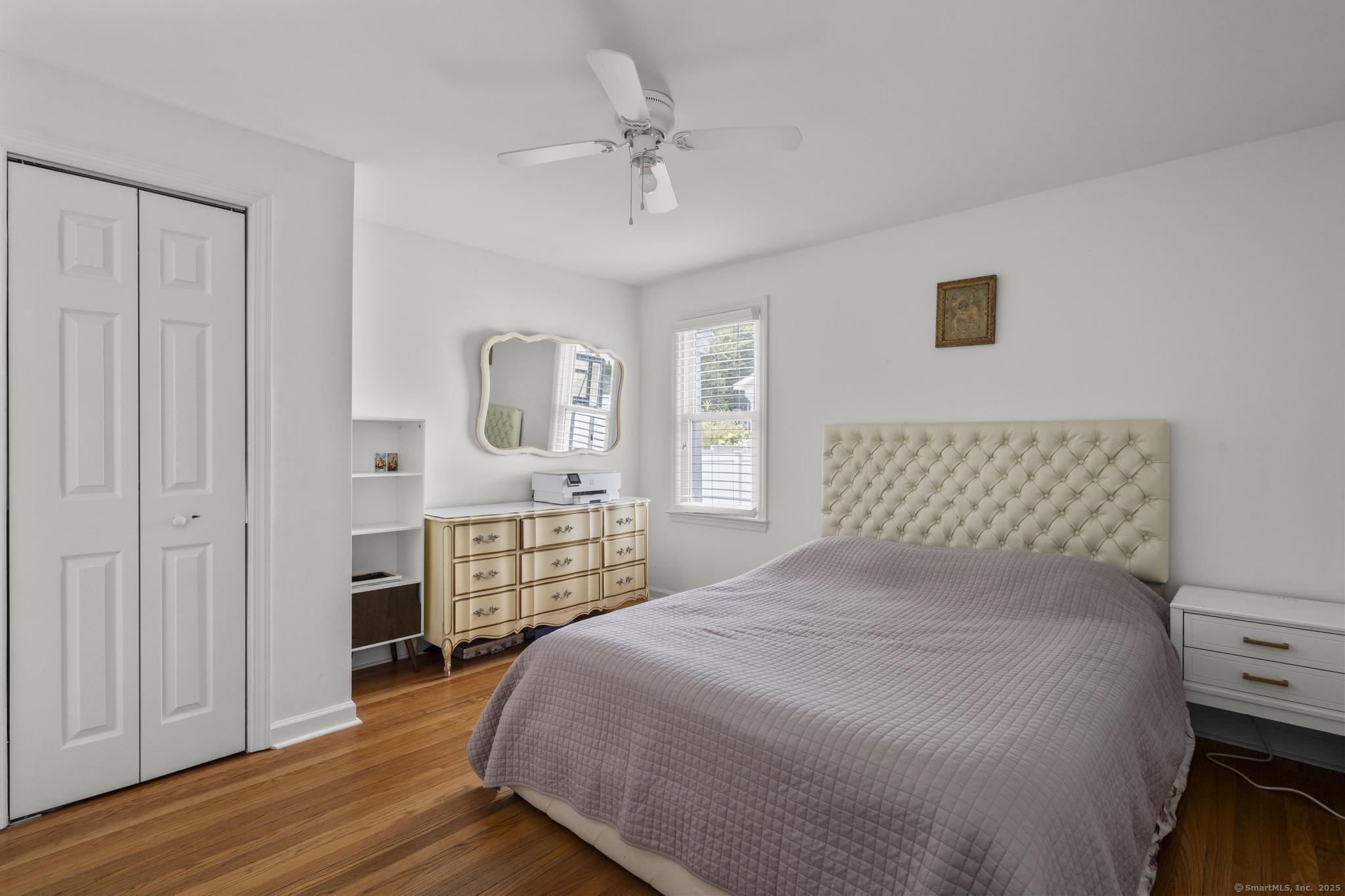 214 Country Road Fairfield, CT 06824 - Photo 10 of 20 a bedroom with a large bed a chandelier and closet