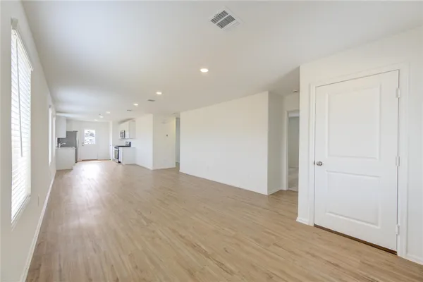 a view of a big room with wooden floor and windows