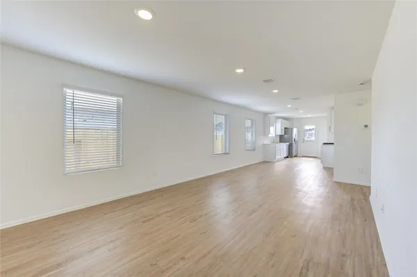 a view of empty room with wooden floor and windows
