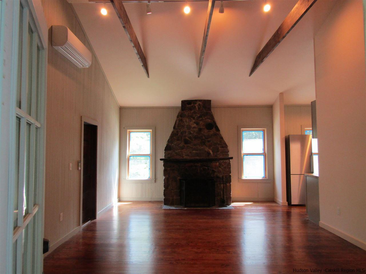 64 Macdaniel Road Woodstock, NY 12498 - Photo 13 of 35 an empty room with wooden floor fireplace and windows