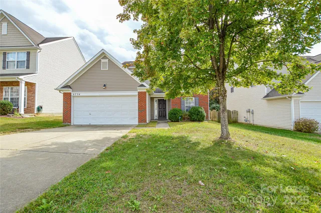 a front view of house with yard and trees