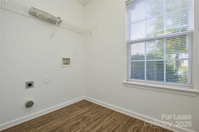 a view of a room with wooden floor and small window