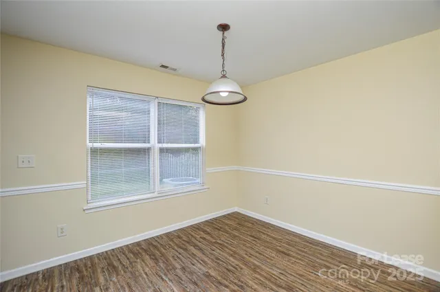 a view of a room with wooden floor closet and windows