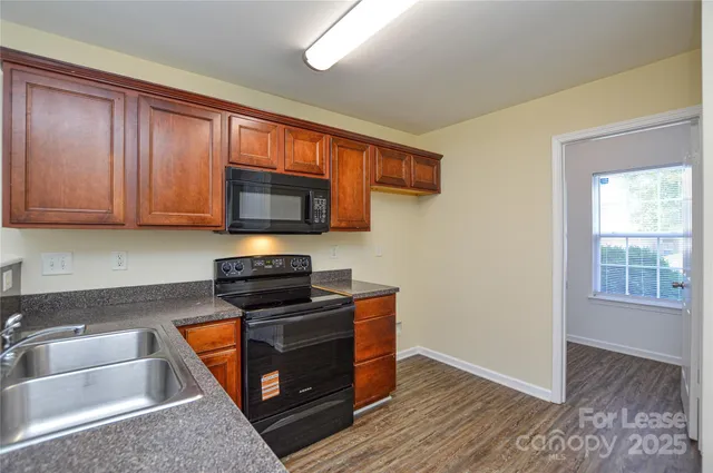 a kitchen with stainless steel appliances wooden cabinets and a stove top oven
