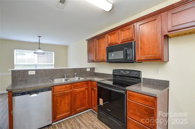 a kitchen with stainless steel appliances granite countertop a sink stove and microwave