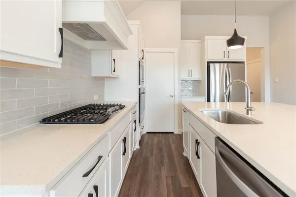 a kitchen with stainless steel appliances a sink stove and refrigerator