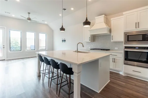 a kitchen with a table chairs sink and cabinets
