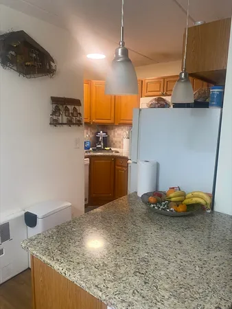 a kitchen with granite countertop a sink a stove and cabinets