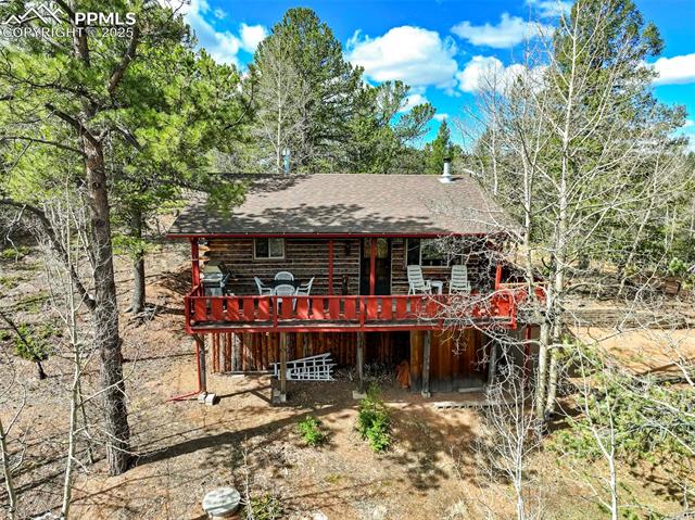 616 Timber Ridge Road Divide, CO 80814 - Photo 6 of 34 Back of property with log exterior, a wooden deck, and roof with shingles