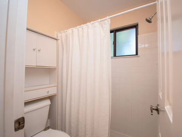 a bathroom with a shower curtain and a window