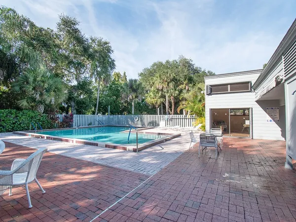 a view of a backyard with couches under an umbrella