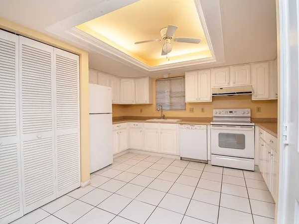 a kitchen with a white cabinets and white appliances