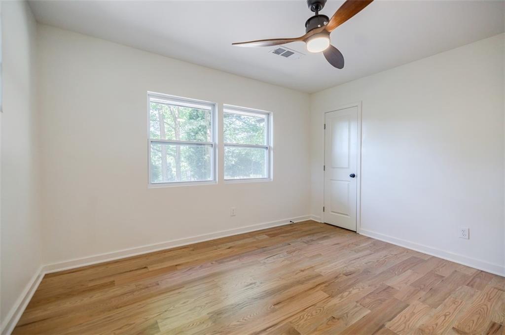3154 North Druid Hills Road Northeast Decatur, GA 30033 - Photo 75 of 82 an empty room with wooden floor ceiling fan and windows