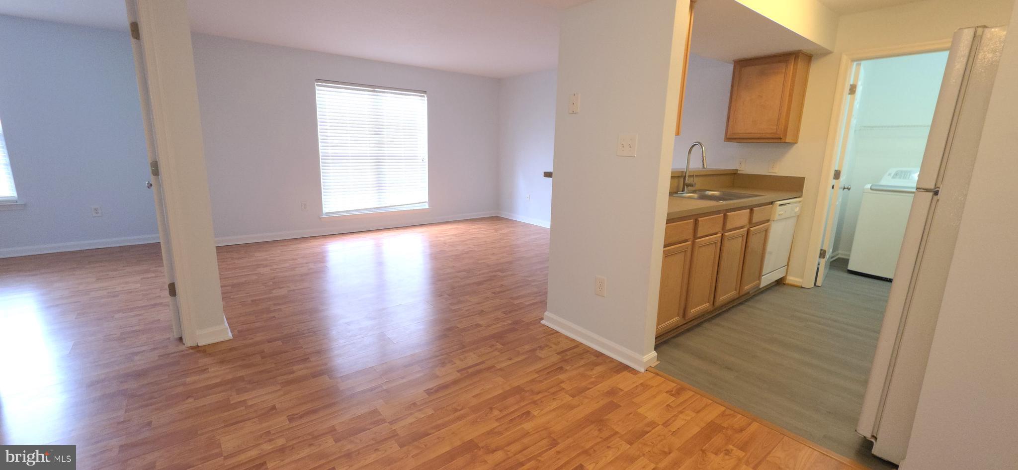a view of a kitchen with wooden floor and electronic appliances