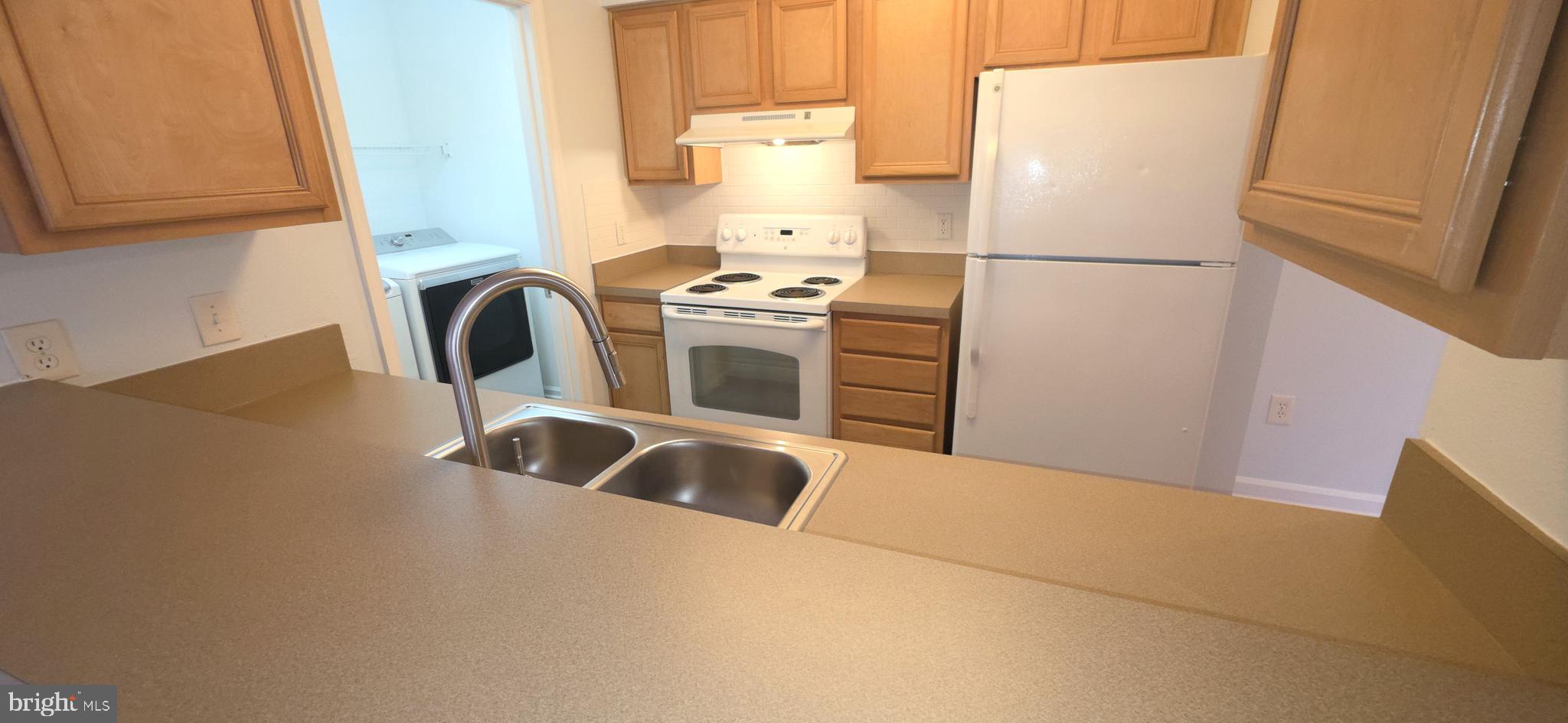 11228 Torrie Way, Unit G Bealeton, VA 22712 - Photo 13 of 30 a kitchen with refrigerator a stove a microwave and cabinets