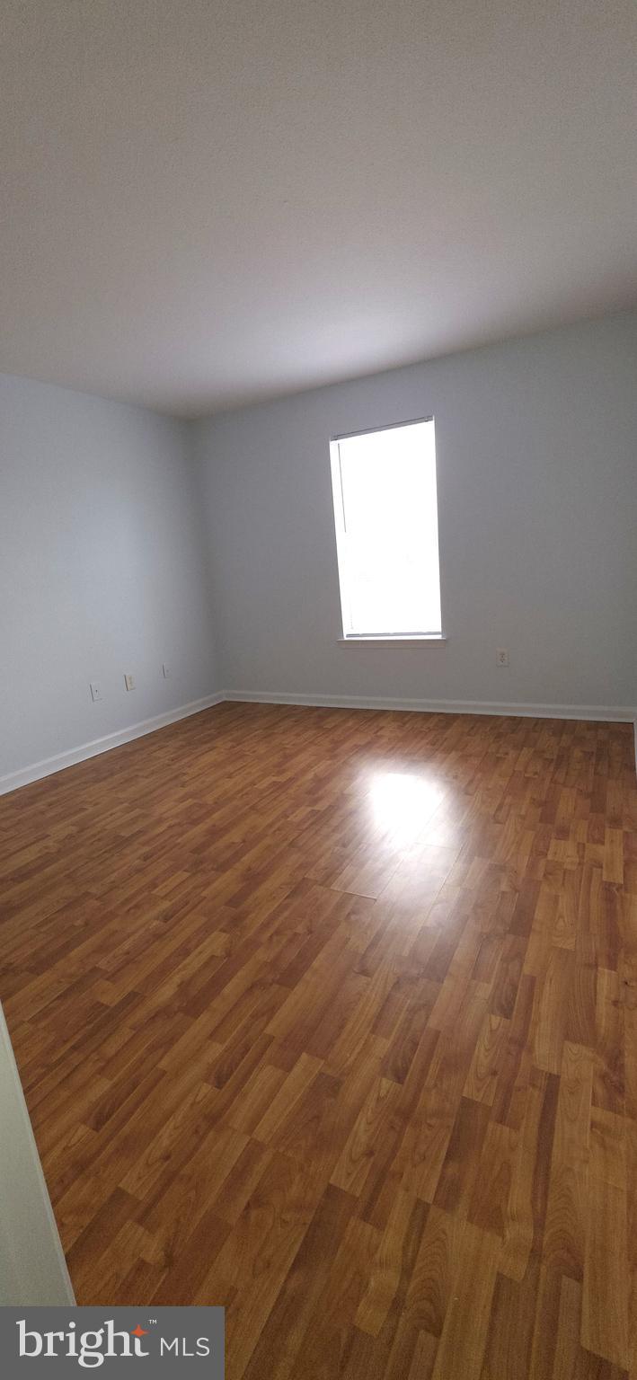 11228 Torrie Way, Unit G Bealeton, VA 22712 - Photo 17 of 30 an empty room with wooden floor and windows
