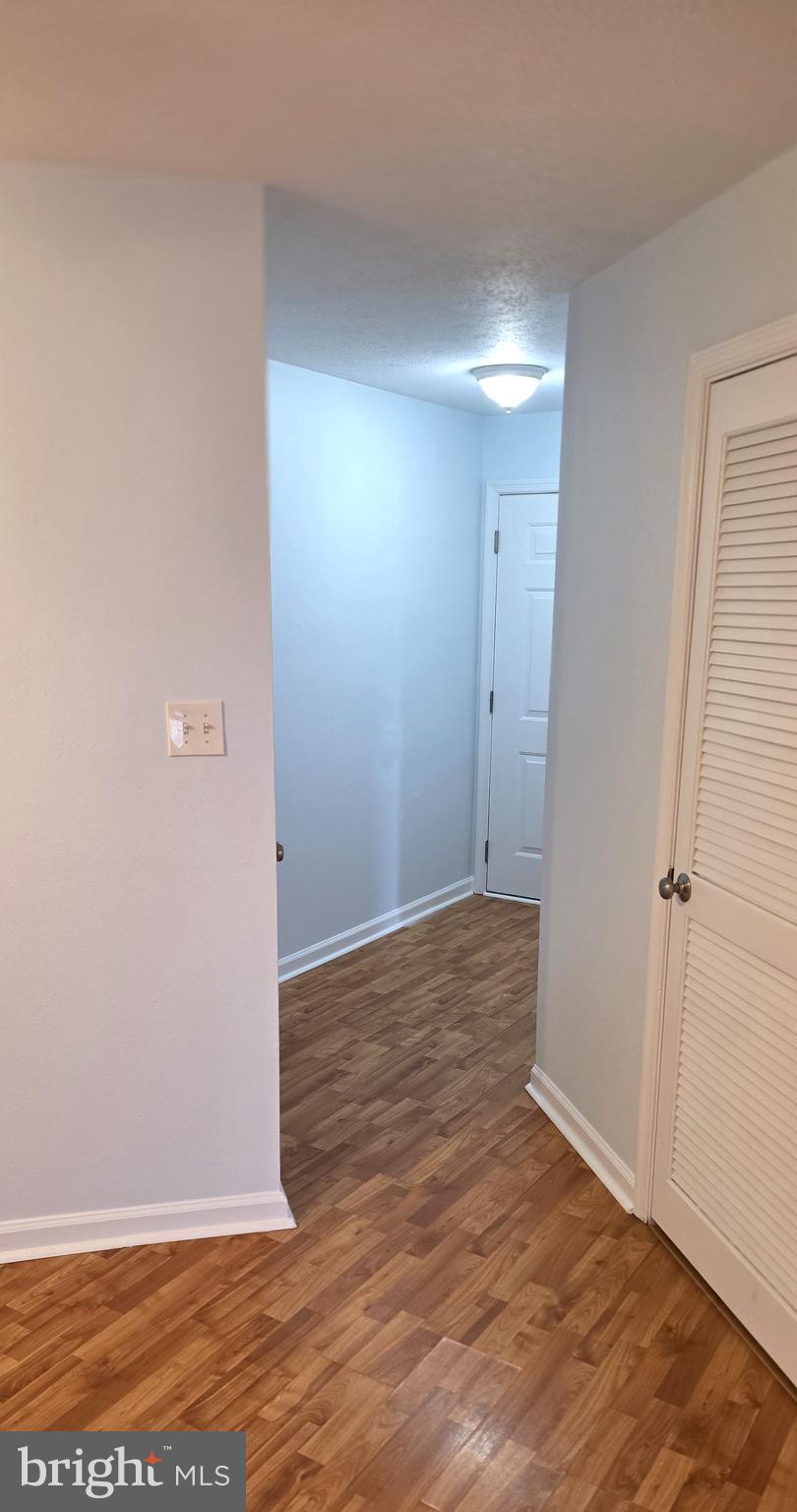 11228 Torrie Way, Unit G Bealeton, VA 22712 - Photo 6 of 30 a view of an empty room with wooden floor and a window