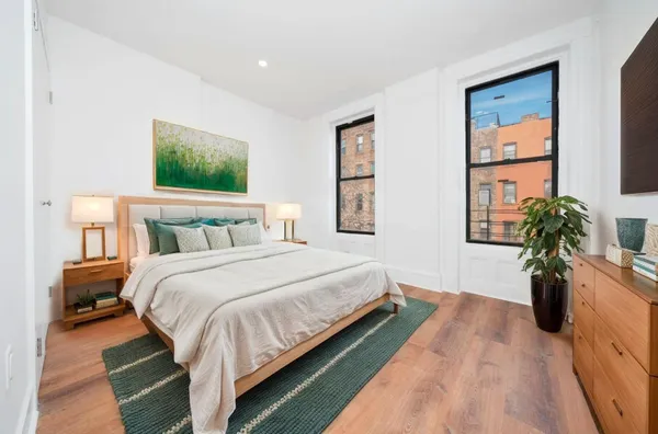 a bedroom with a bed and a potted plant