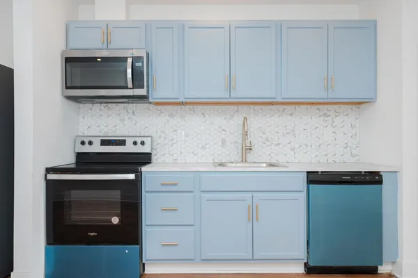 a kitchen with granite countertop white cabinets and stainless steel appliances
