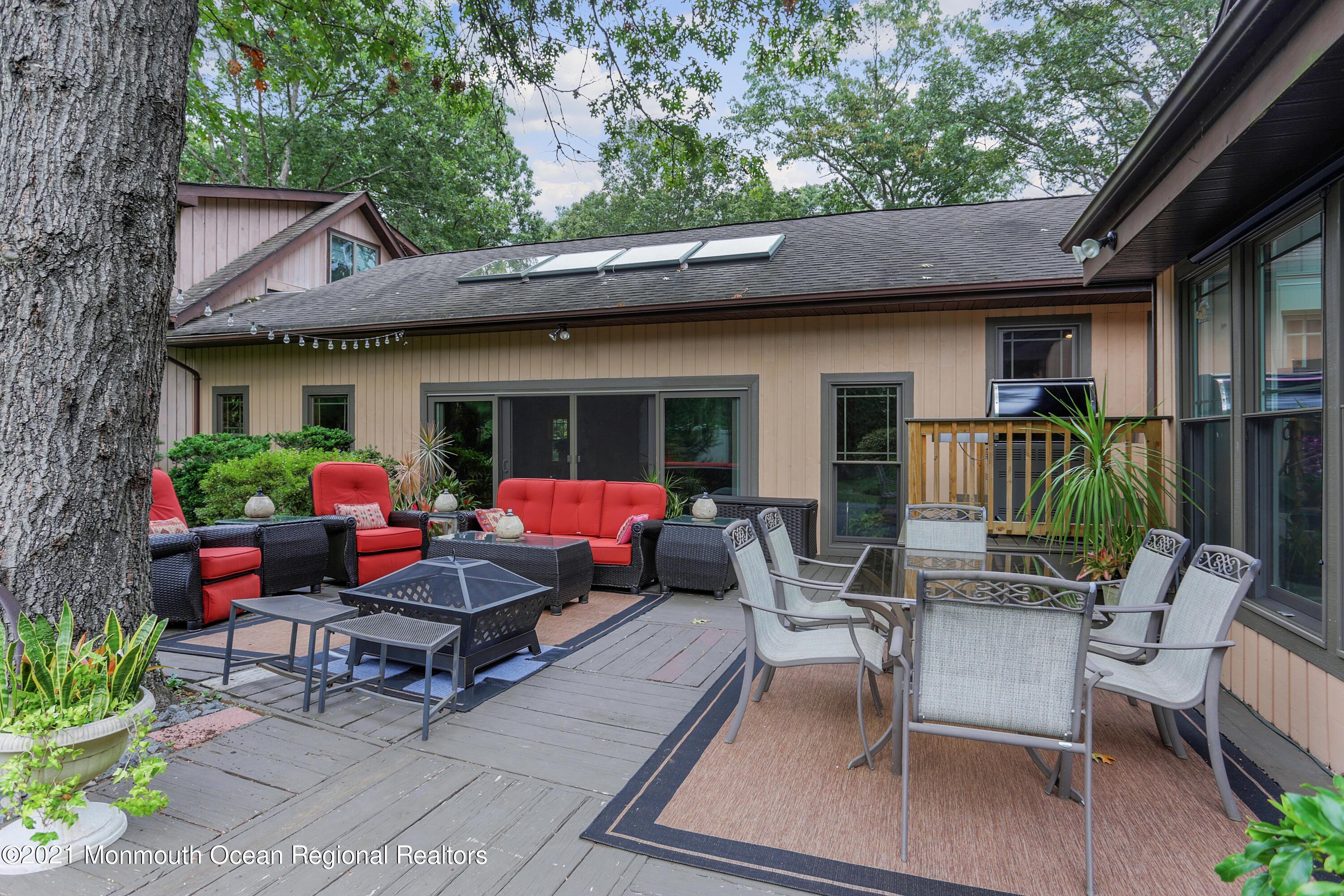 719 Gail Chambers Road Jackson, NJ 08527 - Photo 16 of 34 a view of a patio with table and chairs potted plants and a large tree