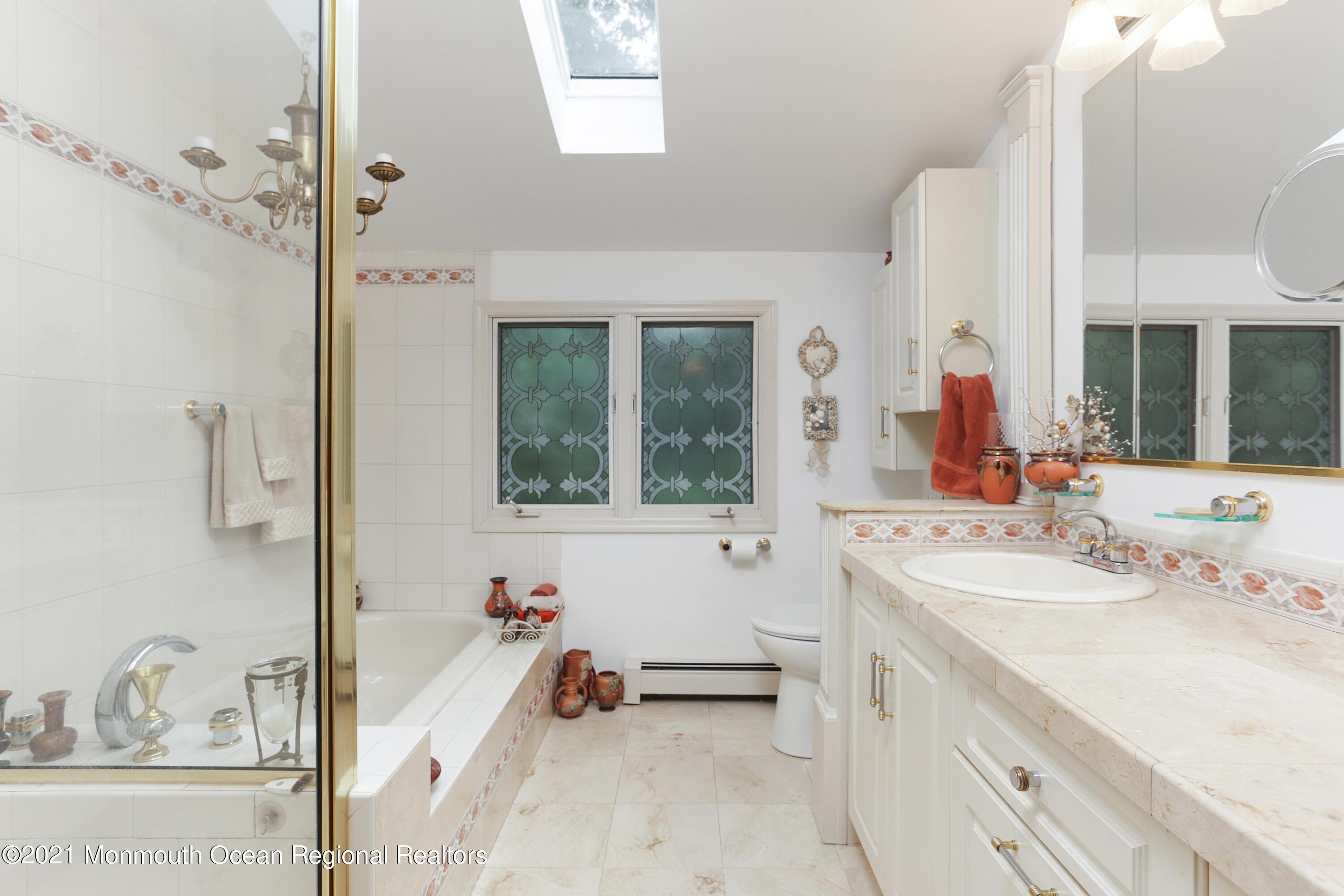 719 Gail Chambers Road Jackson, NJ 08527 - Photo 28 of 34 a bathroom with a tub sink and mirror