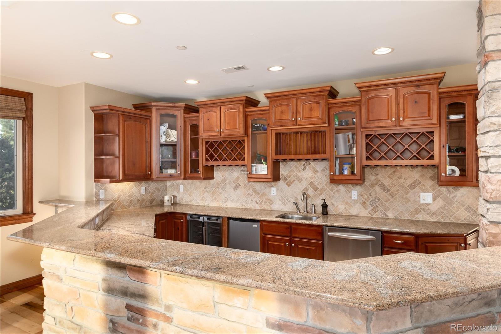 13079 Whisper Canyon Road Castle Pines, CO 80108 - Photo 34 of 50 a kitchen with stainless steel appliances granite countertop a sink and a refrigerator