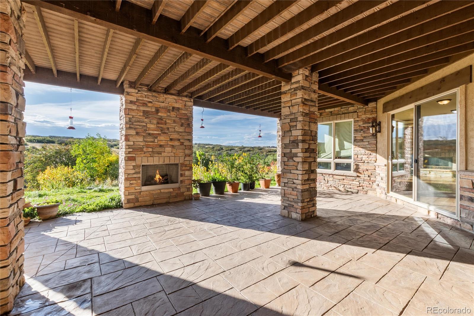13079 Whisper Canyon Road Castle Pines, CO 80108 - Photo 42 of 50 a view of a porch with a table and chairs and potted plants