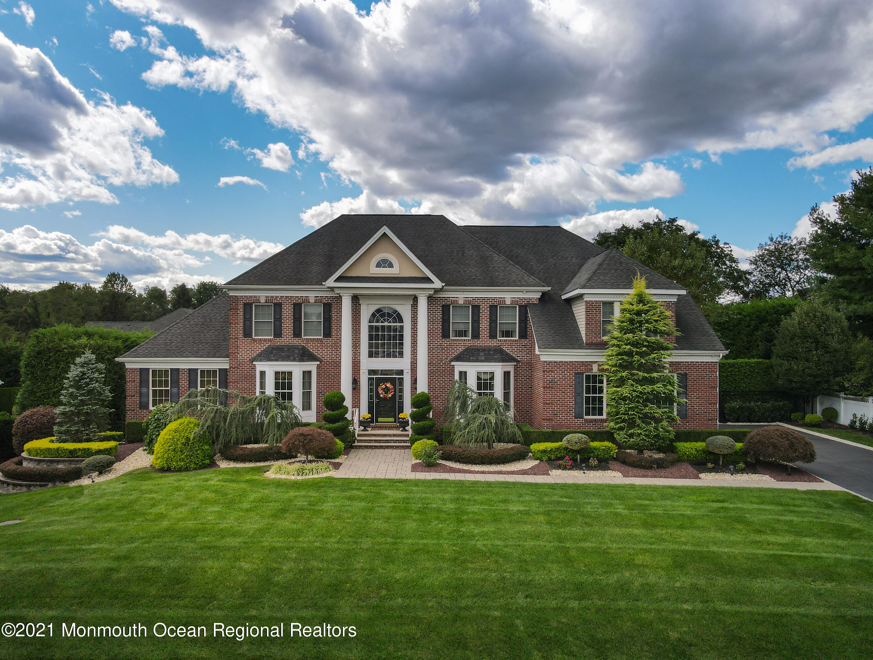 a front view of multiple houses with yard and green space