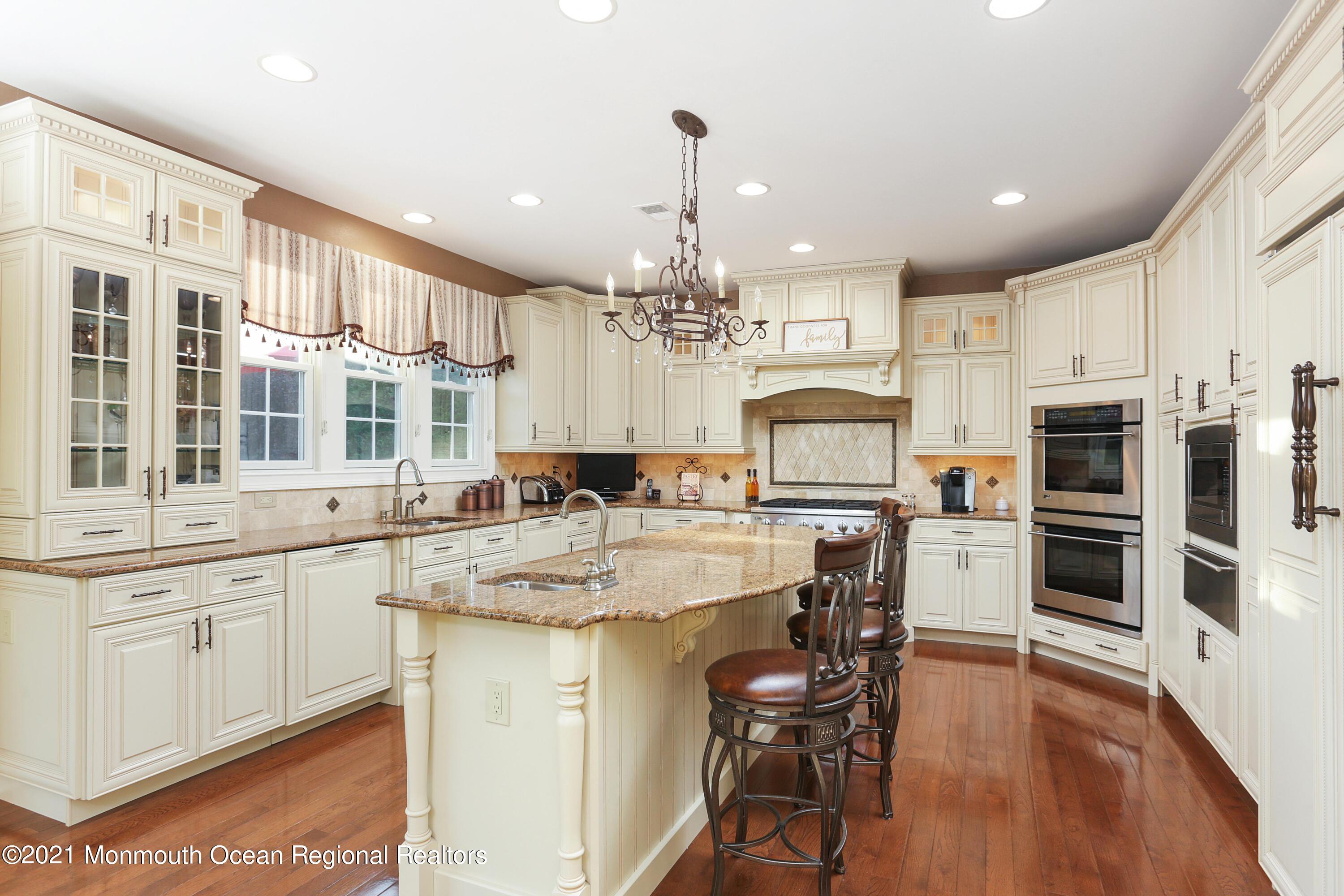 4 Yorktown Road Morganville, NJ 07751 - Photo 18 of 64 a kitchen with stainless steel appliances granite countertop a stove top oven a refrigerator a sink and a island