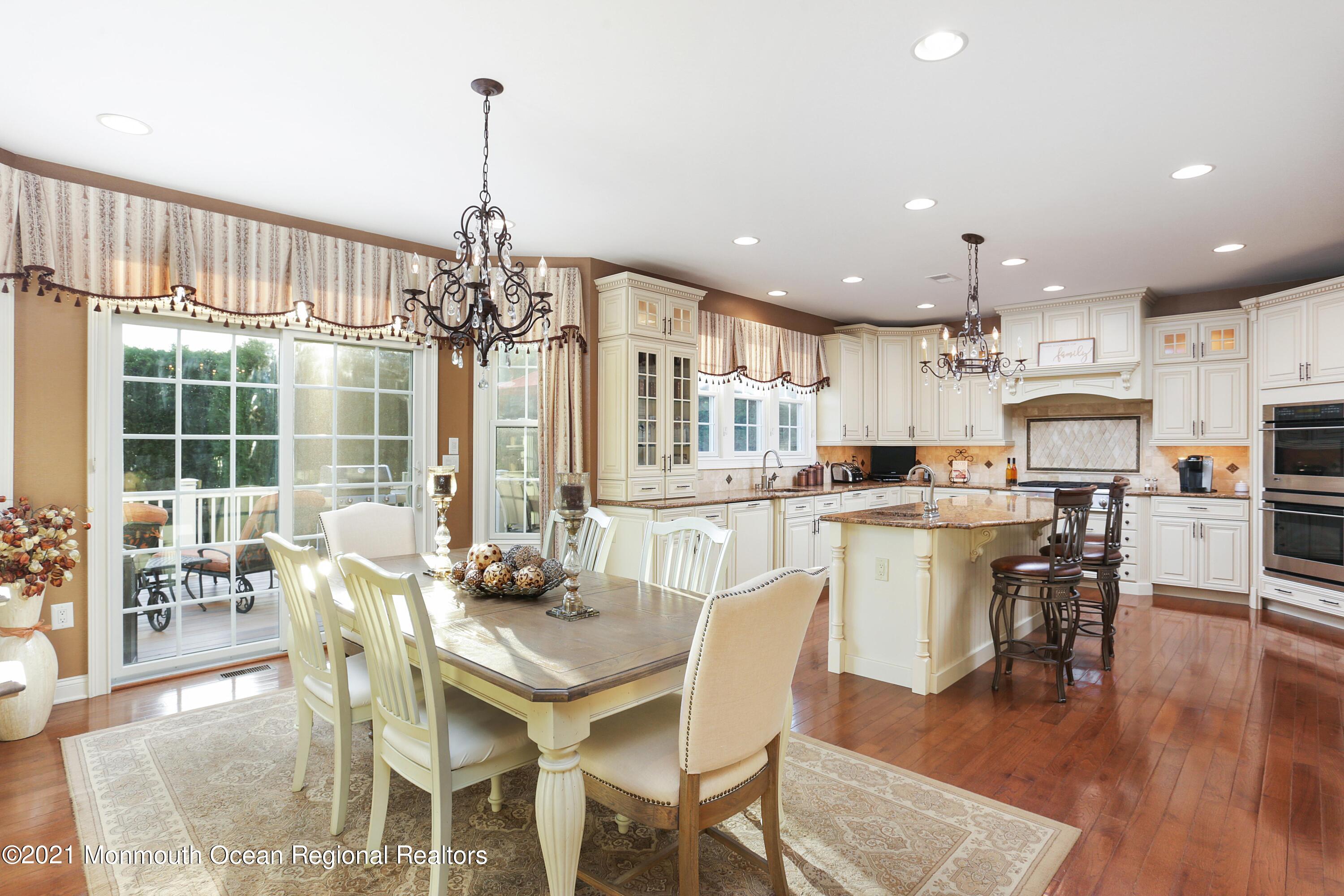 4 Yorktown Road Morganville, NJ 07751 - Photo 22 of 64 a dining room with kitchen island dining table and a chandelier