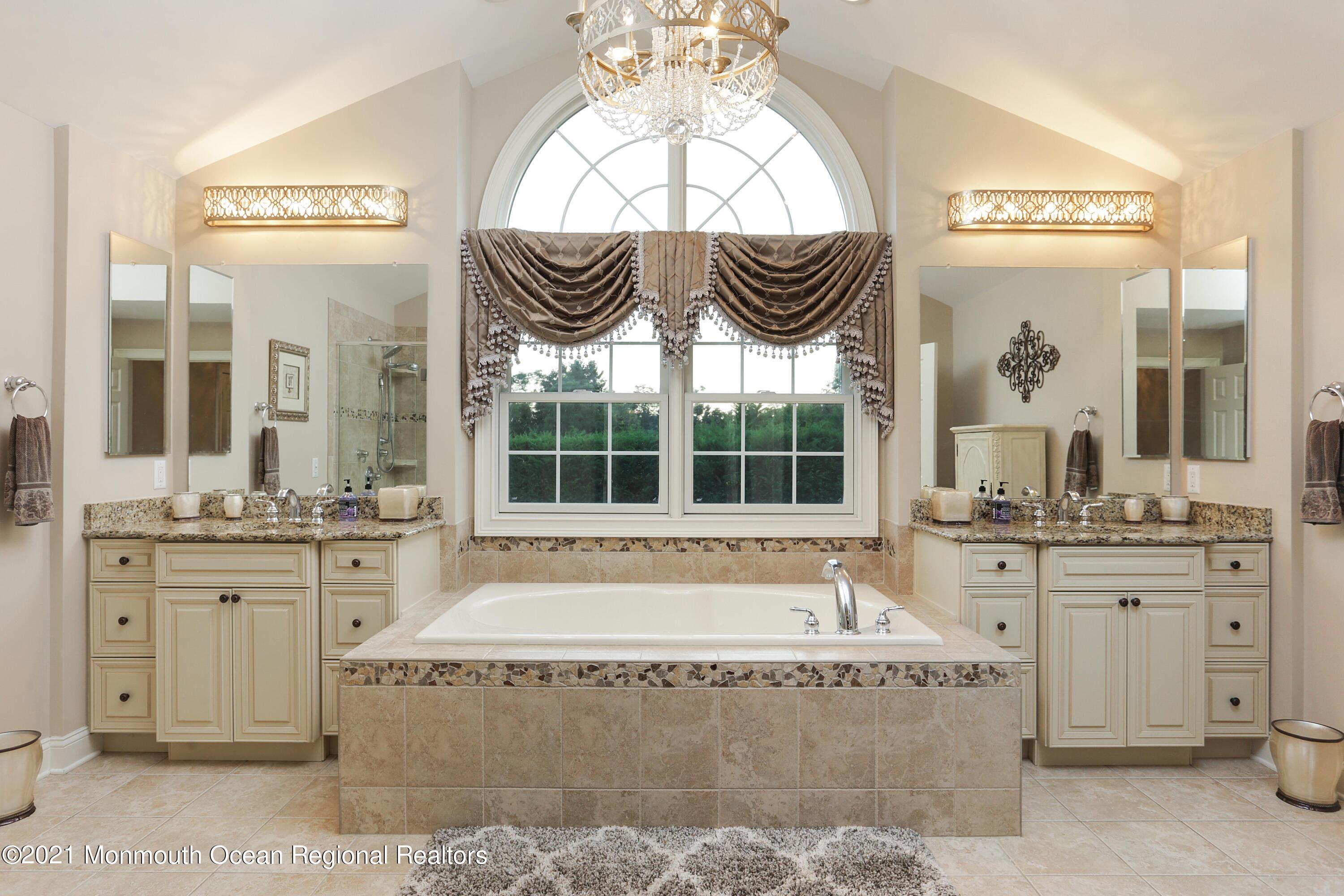 4 Yorktown Road Morganville, NJ 07751 - Photo 28 of 64 a spacious bathroom with a granite countertop tub and a large window