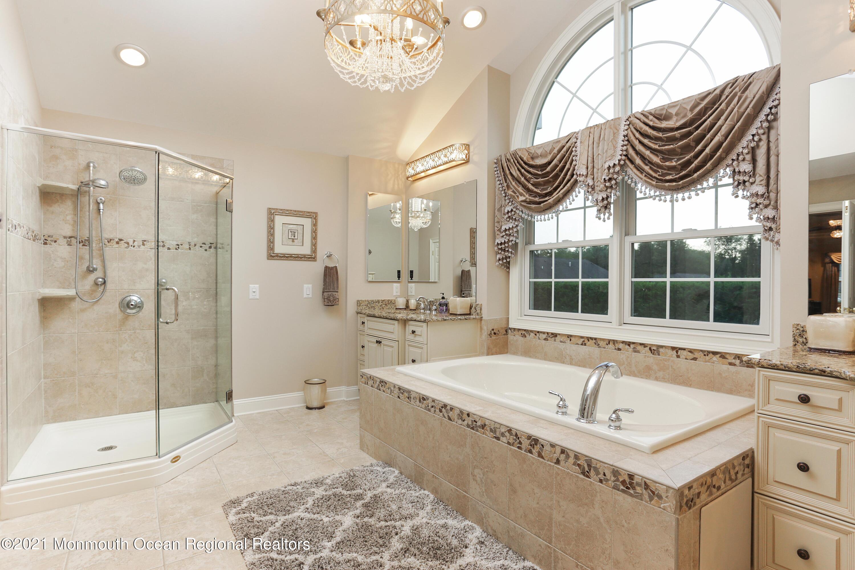 4 Yorktown Road Morganville, NJ 07751 - Photo 29 of 64 a bathroom with a tub a sink and a large mirror