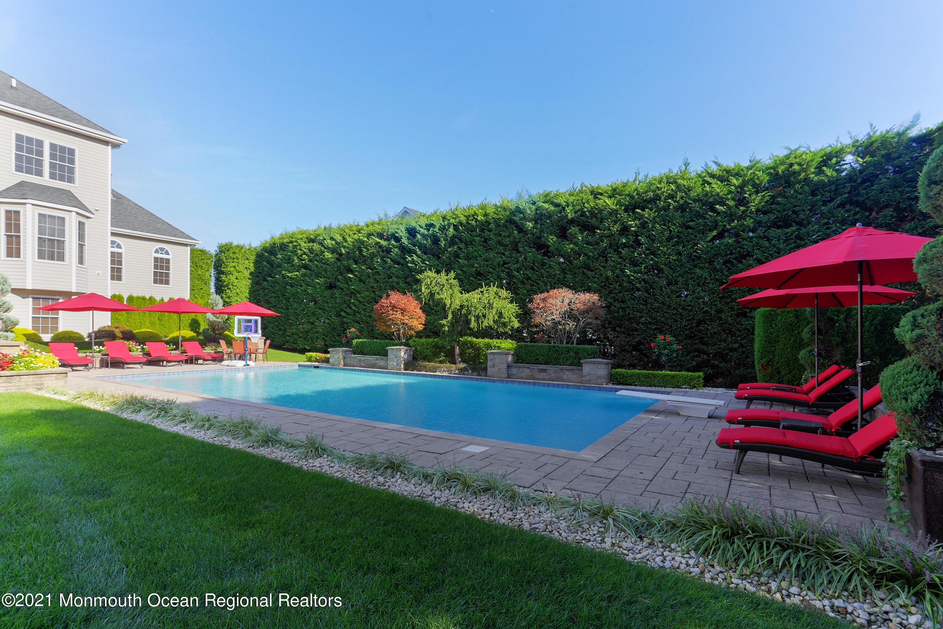 4 Yorktown Road Morganville, NJ 07751 - Photo 48 of 64 a garden view with table and chairs under an umbrella