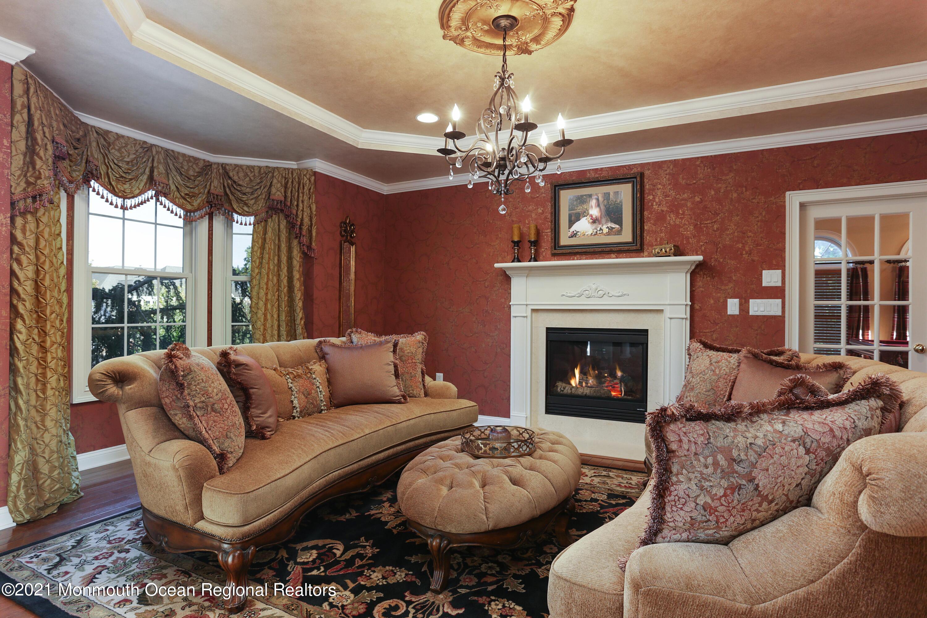 4 Yorktown Road Morganville, NJ 07751 - Photo 8 of 64 a living room with furniture a chandelier and a fireplace