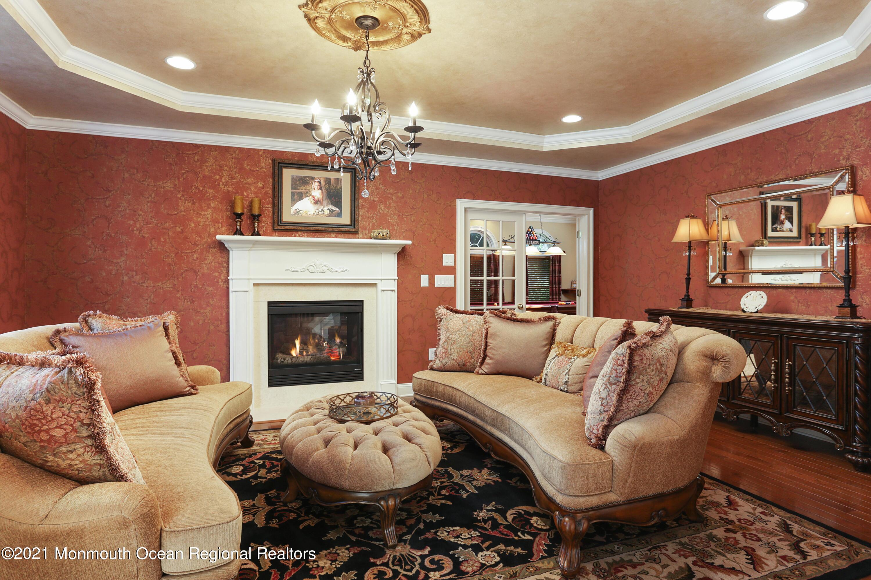4 Yorktown Road Morganville, NJ 07751 - Photo 9 of 64 a living room with furniture a chandelier and a fireplace