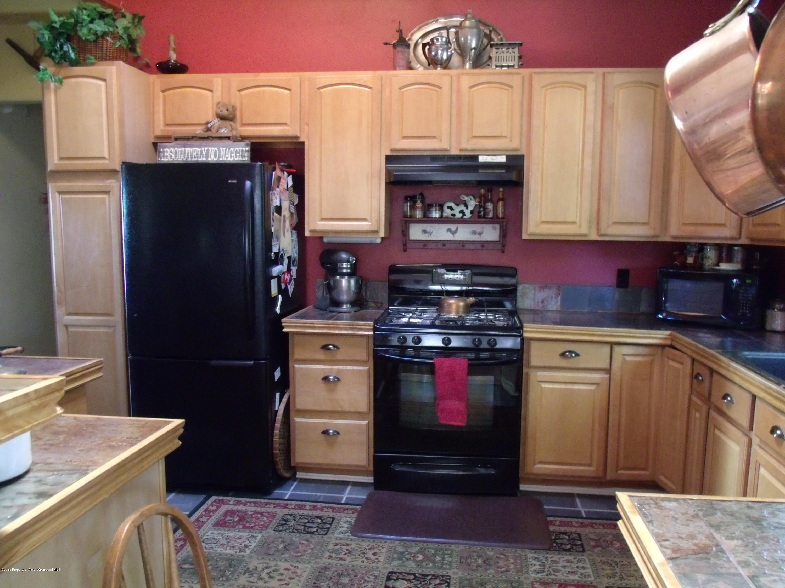 570 Elm Court Rifle, CO 81650 - Photo 6 of 15 a kitchen with stainless steel appliances granite countertop a stove a refrigerator and cabinets