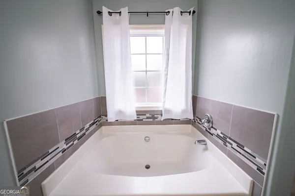 a bath tub sitting in a bathroom next to a window