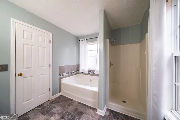 a white bath tub sitting next to a shower