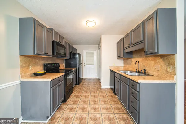 a kitchen with stainless steel appliances granite countertop a sink stove and cabinets